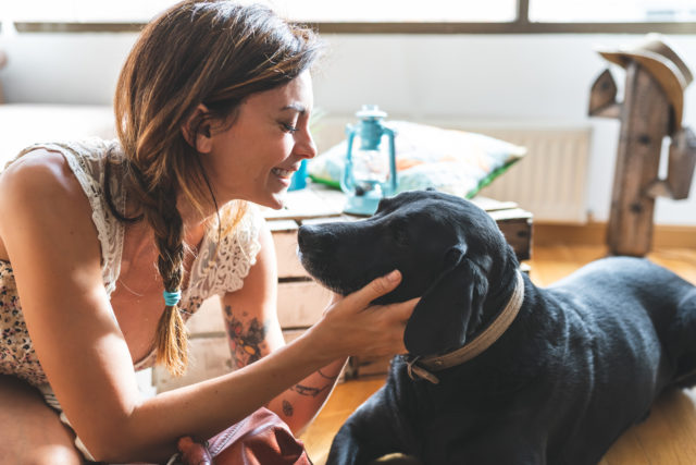 Woman Caressing her Dog at Home.