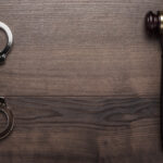 handcuffs and judge gavel on wooden background